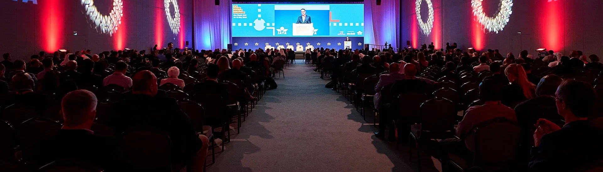 Conference audience facing the stage in an ADNEC hall